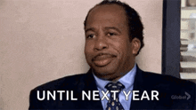 a man in a suit and tie is making a funny face and saying `` until next year '' .