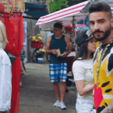 a man with a beard is standing next to a woman in a crowd of people .