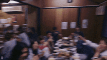 a blurry photo of a group of people sitting around a table with the letter d visible