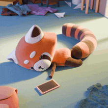 a stuffed animal is laying on the floor next to a phone