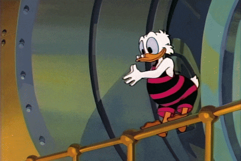 Scrooge dives into his big pile of coins and swims around