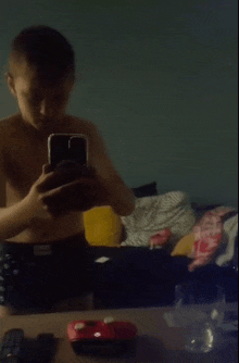 a boy taking a picture of himself in a mirror