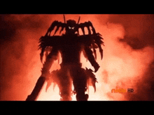 a silhouette of a robot standing in front of a fire with the nick hd logo visible