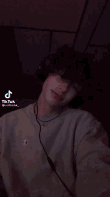 a young man is wearing headphones and a tiktok sticker
