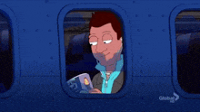 a man wearing ear buds is looking out of an airplane window at a picture of a man in a car on the screen