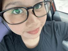 a woman wearing glasses and a black shirt has a toyota sticker on the windshield