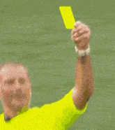a soccer player in a red shirt is getting a yellow card