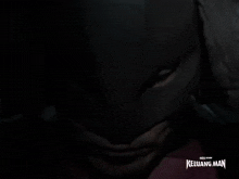 a close up of a man wearing a mask with the words keluarg man behind him