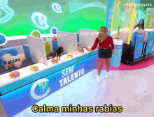 a woman stands in front of a sign that says calma minhas rabias