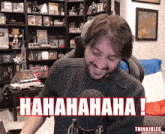 a man in a sweater is laughing in front of a microphone with the words " hahahaha " written on the bottom