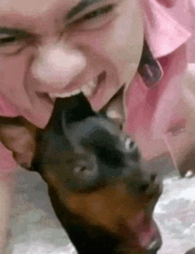 a man is licking a dog 's nose .