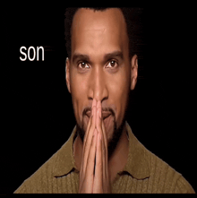 a man with his hands folded in front of his face with the word son above him
