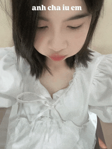a girl wearing a white shirt with the words anh cha iu em written on the bottom