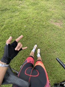 a person giving the middle finger while riding a bike in the grass