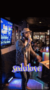 a man singing into a microphone with the word sedulove on the bottom right