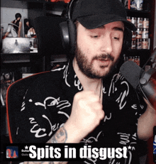 a man wearing headphones and a hat says " spits in disgust " in front of a microphone