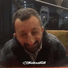 a man covering his face with his hands with a telegram icon behind him that says @koksalgif