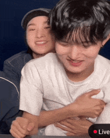two young men are hugging each other with a red live button in the corner