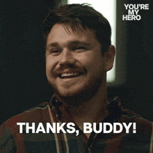 a man in a plaid shirt is smiling and says " thanks buddy "
