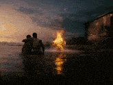 two men are standing in the water looking at a fire coming out of the water