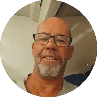 a man with glasses and a beard is smiling