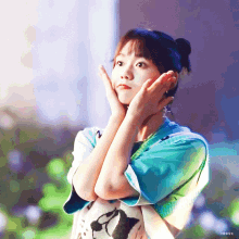 a girl with her hands on her face looks up at the sky