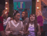 a group of women are dancing in a room with mirrors and lights