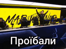 a group of people are sitting at a table with their arms in the air in front of a sign that says marathon .