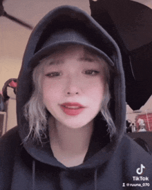 a woman wearing a hat and a hoodie has a tiktok account