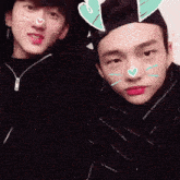 two young men wearing hearts on their faces
