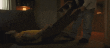 a person in a yellow shirt is laying on the floor while another person holds their legs up