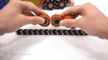 a person is playing with magnetic beads made by the magnetic man