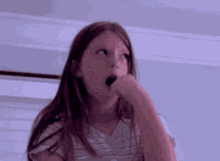 a young girl is making a funny face with her mouth open .