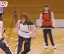 a group of girls are playing a game on a basketball court with a sign that says ' ao ' on it