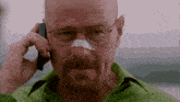 a man with a bandage on his nose talking on a cell phone