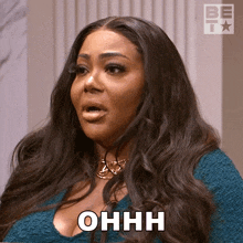 a woman with long hair says ohhh in a blue shirt