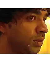 a close up of a man with a tear coming out of his eye .