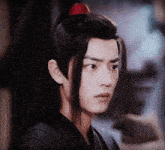 a young man with long hair and a red ponytail