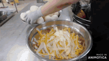 a person is preparing food in a metal bowl that says made in animatica on the bottom