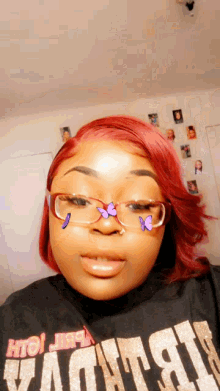 a woman with red hair and glasses is wearing a black shirt that says vaughn on it