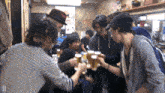 a group of people toasting with beer mugs in front of a sign that says kirin