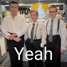 three men in suspenders and ties are standing in front of a sign that says " yeah "