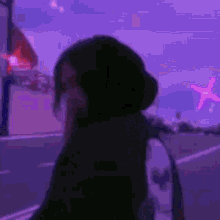a blurry picture of a person standing in front of a purple sky with a plane in the background .