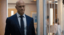 a man in a suit and tie standing in a hallway