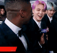 a man with purple hair is holding a microphone that says access on it