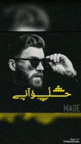 a black and white photo of a bearded man wearing sunglasses with arabic writing