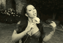 a woman in a black bra is holding a rose in her hand