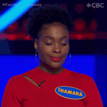 a woman wearing a red sweater that says thama yes
