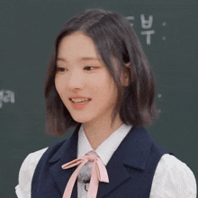 a girl in front of a blackboard that says t