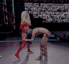 two women wrestling on a stage with a crowd watching